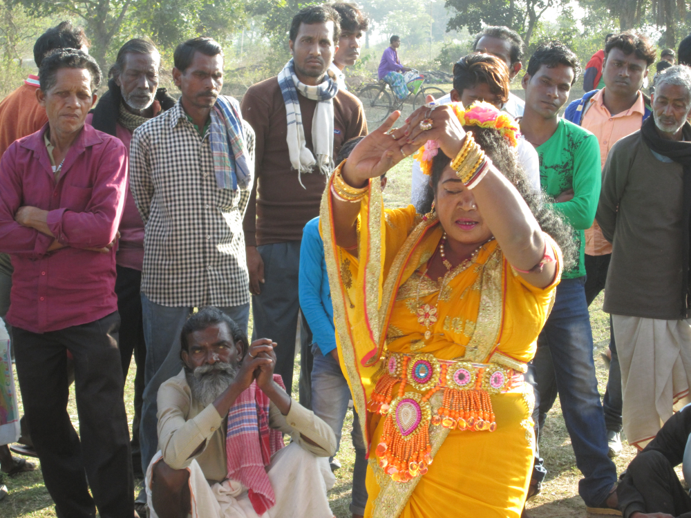 চিত্র ৭. ডুবকিডি গ্রামের ভানসিংহ মেলায় নাচনি নাচ প্রদর্শন। শিল্পীর নাম পস্তুবালা দেবী কর্মকার। আগে এই নাচে মাইক ব্যবহৃত হত না, কিন্তু এখন সময়ের সঙ্গে তাল মিলিয়ে মাইকের প্রচলন হয়েছে। (সৌজন্যে: সোহম দাস)