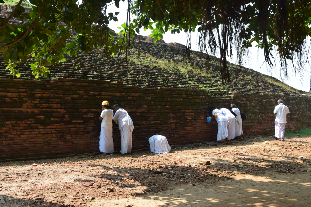 चित्र ९. पूर्वी चम्पारण स्थित केसरिया स्तूप की दीवारों को चूमते व इसकी पूजा करते विदेशों से आए पर्यटक (फोटो : अफ़रोज़ आलम साहिल, अक्टूबर, 2019)