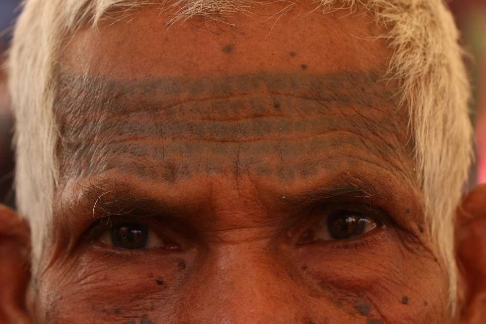 A man with ram-ram godna on his forehand