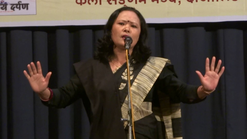 Fig. 3. Pavitra Lama performing her poem, ‘Chourastaa’ at the Gorkha Dukha Nivarak Sammelan Hall, Darjeeling, West Bengal on June 11, 2017. Lama’s black shawl here is an indicator of the silent protest against the imposition of the Bengali language in secondary schools in the Darjeeling Hills where maximum students are Nepali speakers (Courtesy: Rajesh Wokamchha Rai)