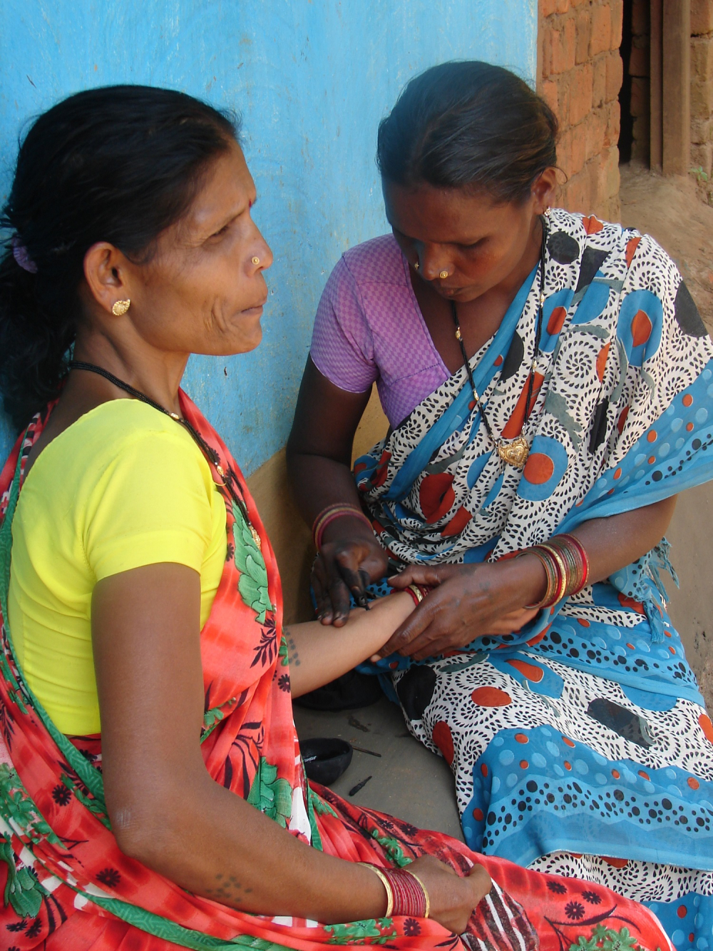 A woman getting godna on her hand