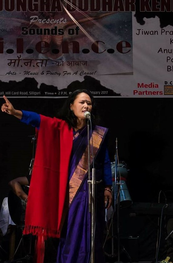 Fig. 4. Pavitra Lama performing her poem, ‘Yashodaharu Parkhibaschhan Krishnalai’ at the Sounds of Silence programme held in Siliguri, West Bengal on February 20, 2017. Lama’s red shawl is representative of the marital status of Yashoda, foster-mother of Lord Krishna on whom the poem is based (Courtesy: Roshan Thakuri)