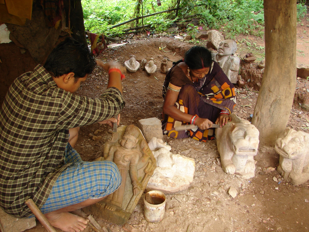 An iron smith working on a stone sculpture