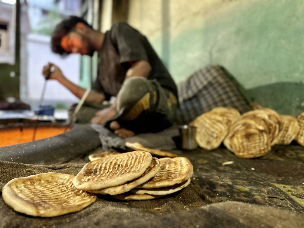 A young apprentice plucking girde out of the Tandoor. (Picture Credits: Taha Mughal)