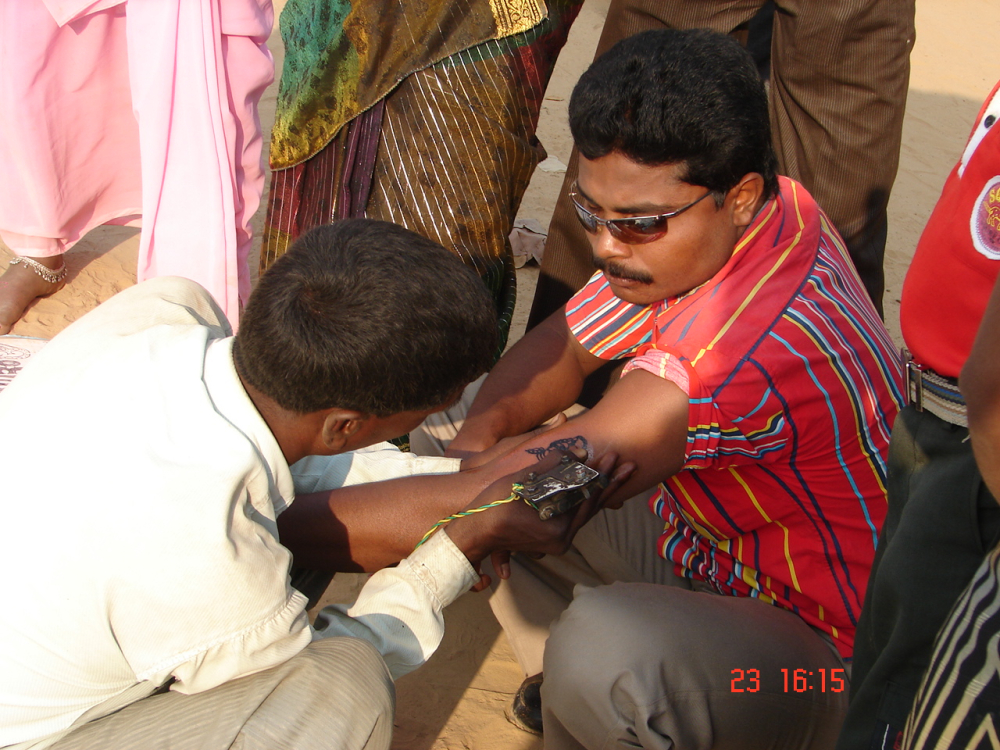A man getting godna on his arm