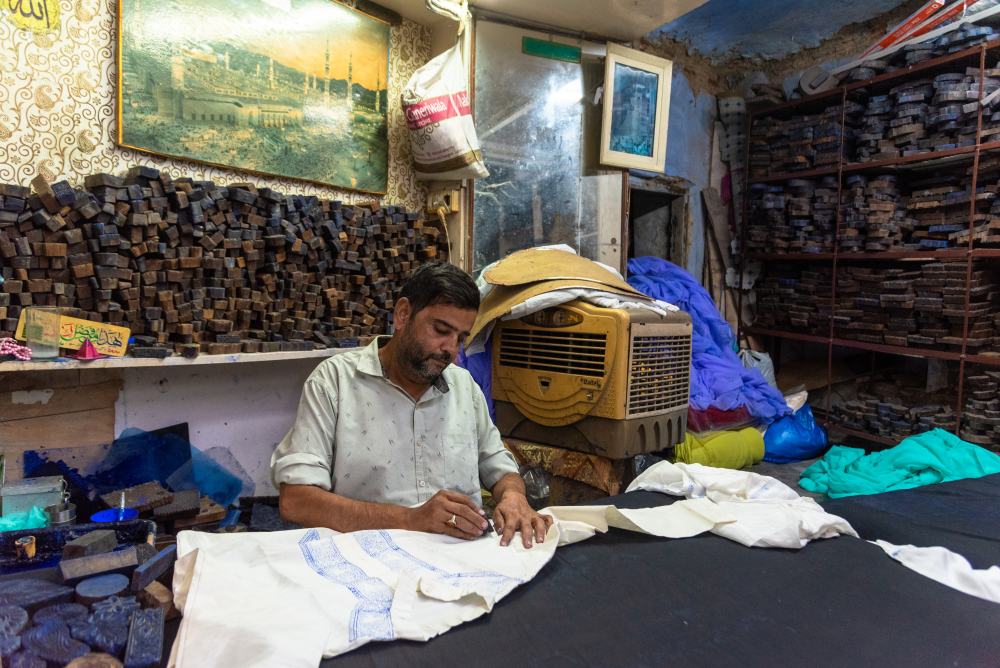 Artisan using wooden blocks to create patterns for the embroidery. (Picture Credits: Monis Khan)