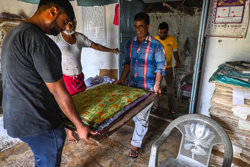 Mohammad Altaf and Sameer Sheikh carry the layers to the press machine. (Picture Credits: Anil Purohit)