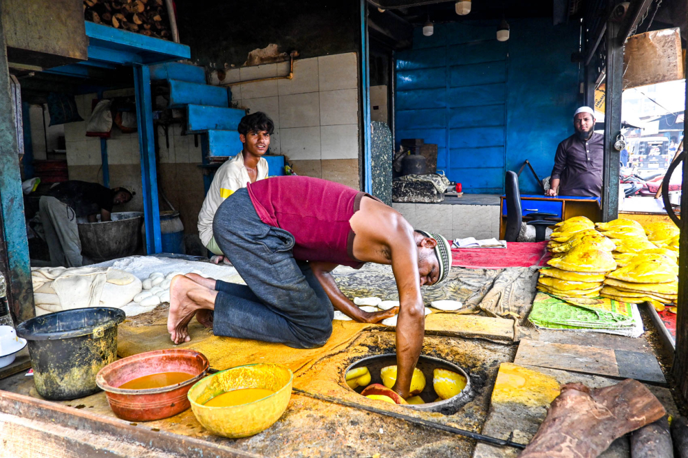 Placing naan in the oven. (Picture Credits: Anil Purohit)