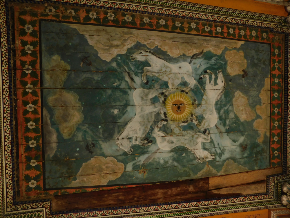 Fig. 6: A smiling sun surrounded by four running white horses among stars, falling flowers, and clouds. Four unoccupied horse-drawn chariots on the four corners of the composition can be detected. Their small size may suggest distance. This painting may have been done by Muskare as there is no mention of any other painter involved with the temple (Photo courtesy: Sritama Halder)