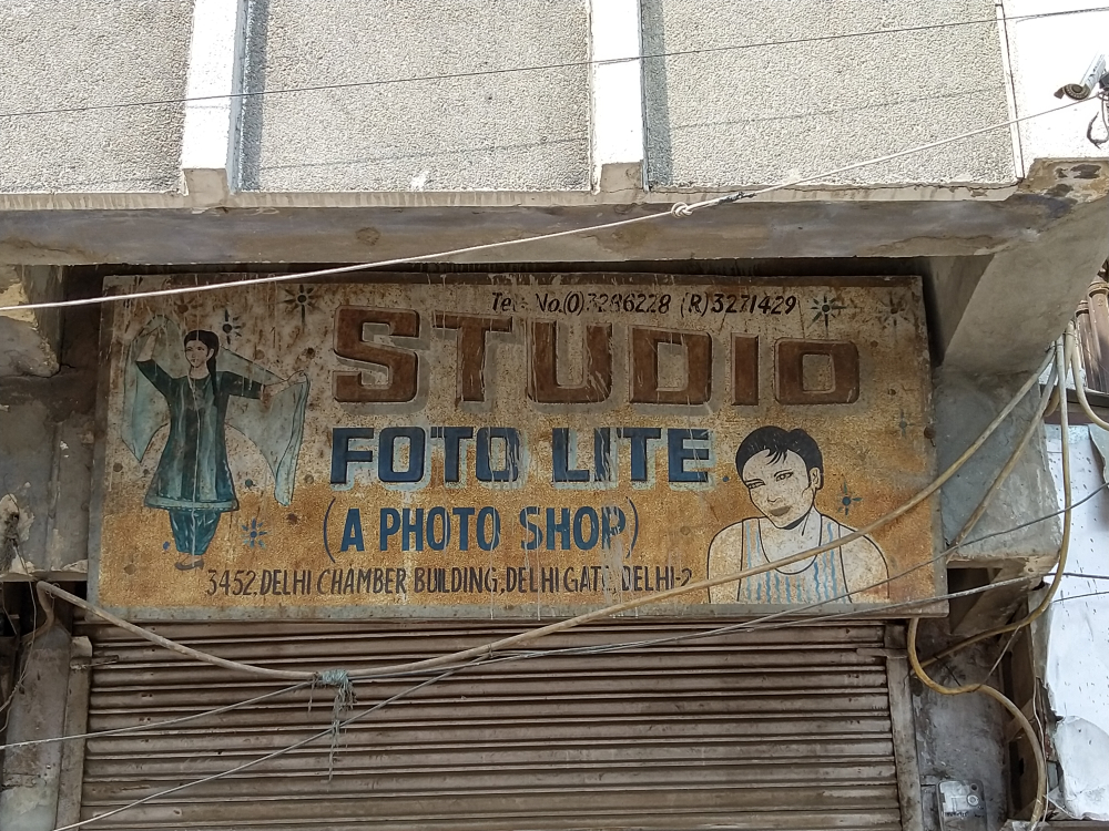 Fig. 6. A signboard of a photography studio in Delhi Gate, which is an example of signage with illustrations. With an image of a man in a vest and a woman flaunting her chunri, Studio Foto Lite’s delightful signboard has the title shape of a megaphone that recalls the typographic designs similar to the poster of the 1974 film Bidaai.