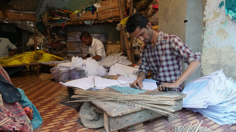 Fig. 2: Attaching bamboo sticks along the kite edges to prevent tearing and add stiffness. (Courtesy: Ashna Patel)