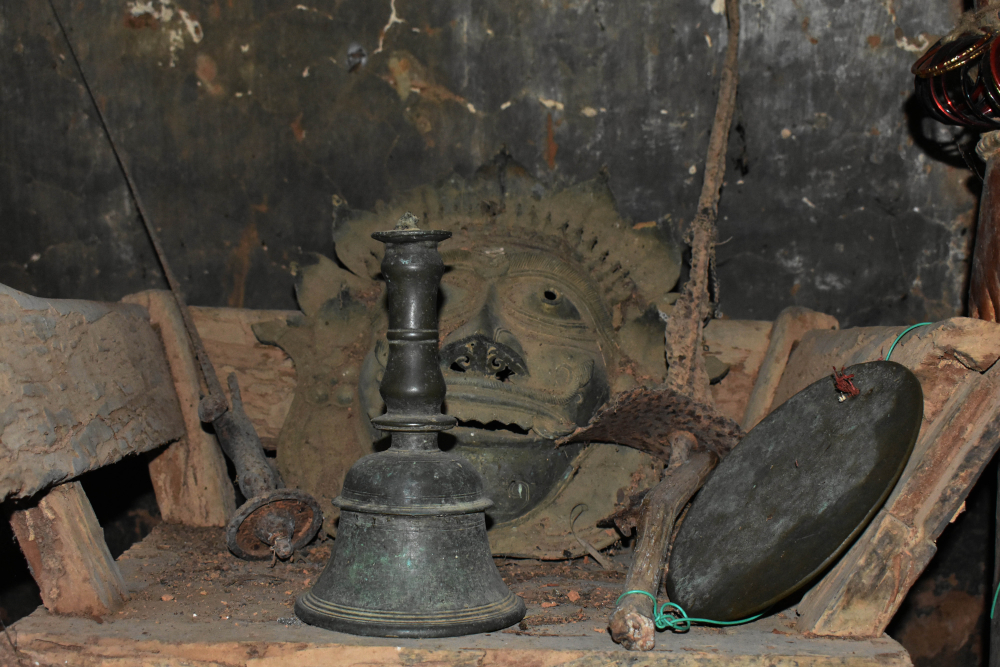 Fig 3: One of the sections of the daivakone at Deroddu Guttu, Nitte. This daiva kone is unaltered for over a hundred years now. The swords, the mask and the two types of bells (the flat one is called jaagate) are placed on a wooden chair called mancha