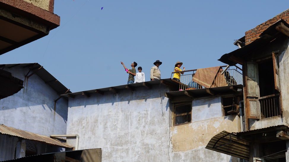 Fig. 7: A family flying kites on a sloping rooftop in Khadia, Ahmedabad. (Courtesy: Ashna Patel)