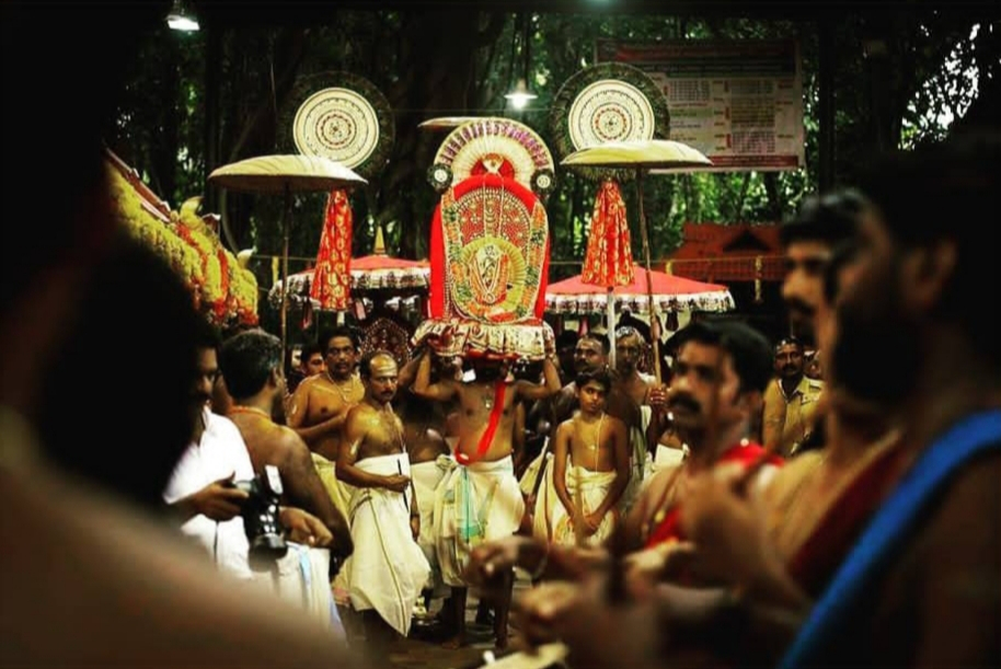 Fig 2. Ceremonial procession at Vetticode temple during Ayilyam festival. The idol of Nagaraja is decorated with flowers and silk, and the chief priest carries the idol from temple to Meppallil Illam. The procession is accompanied by the beats of musical instruments, decorated umbrellas, women carrying lamps, and people chanting mantras. It is believed that one who is blessed by the sight of this procession will be protected from animal poison the coming year 