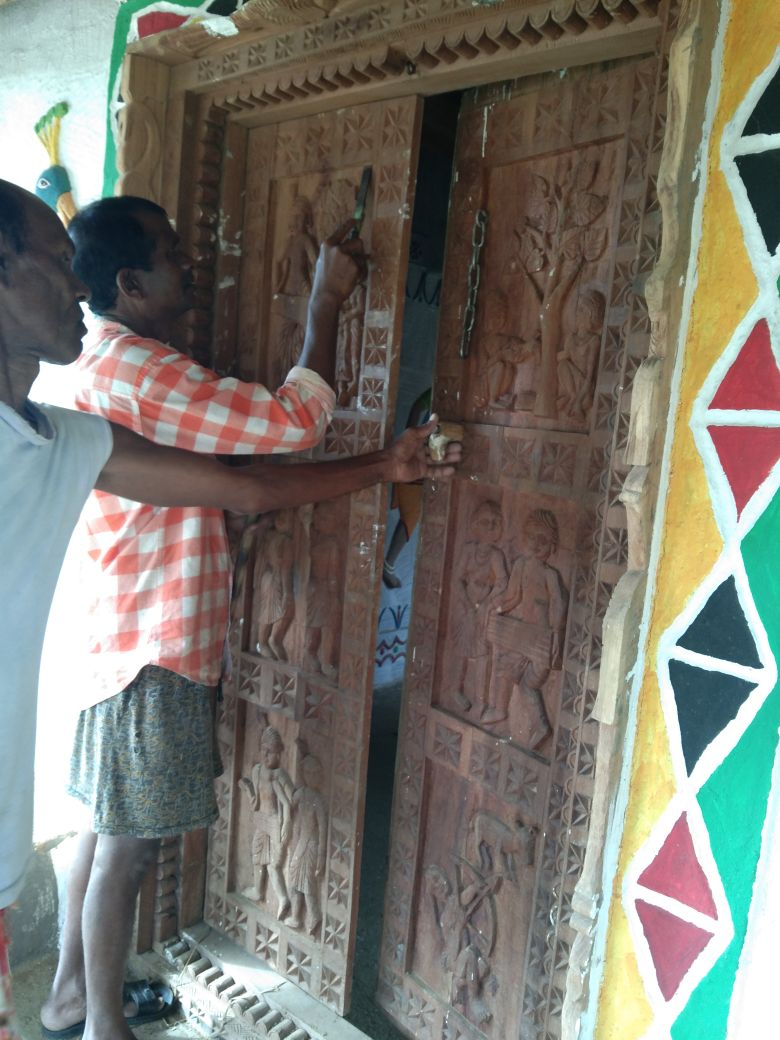 Artists carving out designs on the house door