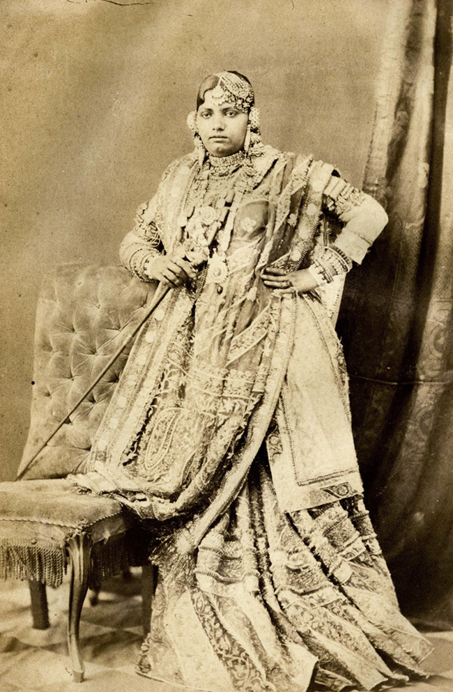 Portrait of a girl in traditional Lucknowi attire from the 1874 album Beauties of Lucknow, reminiscent of depictions in films like Pakeezah and Umrao Jaan. (Picture Credits: Darogah Abbas Ali/Wikimedia Commons)