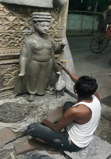 A kumar applies a coat of clay on an idol. (Courtesy: Aaheli Sen)