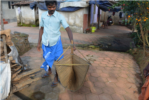 Fig. 4. A Paniya youth with an indigenous fishing trap (Courtesy: Vasundhara Krishnan)