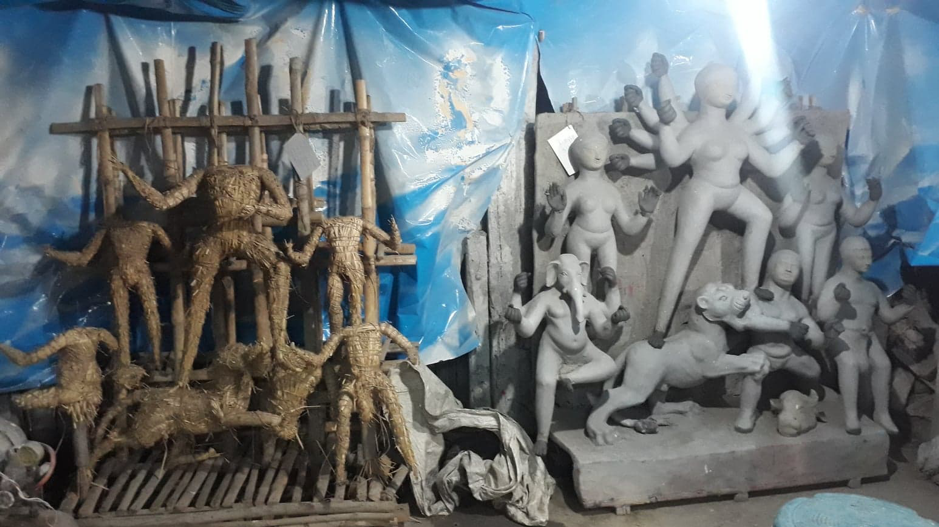 Two stages of idol making. Left: Kathamo wrapped with straw; right: The straw structure covered with mud. (Courtesy: Aaheli Sen)