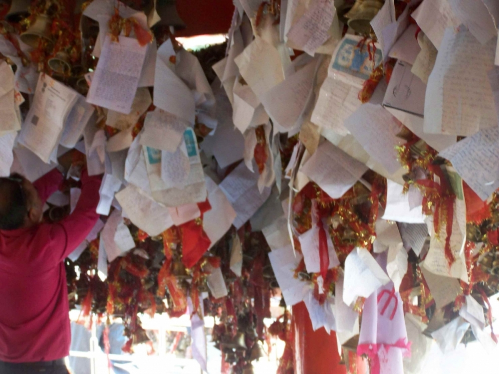 Many tourists are drawn to this unusual sight of hanging prayers. They hang in between hundreds of bells that are offerings to the deity for favours/ justice received.